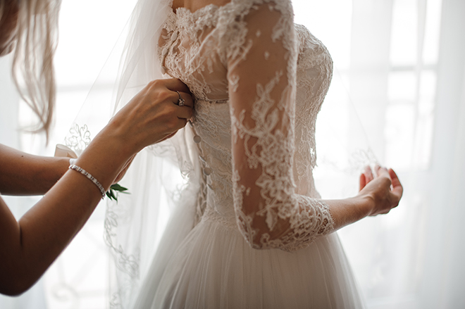 how-to-choose-a-bridal-gown-fashionable-bride-getting-gown-zipped-up