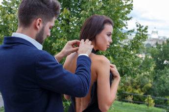 Elegant stylish man help dressing woman outdoor