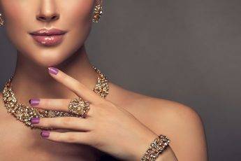 woman-holding-her-finger-to-her-face-showing-ring-bracelet-and-diamond-jewelry