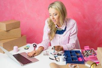 Woman working from home. Making pieces of jewellery and sells them on computer