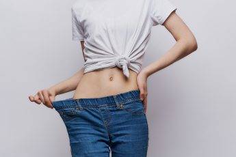 essential-oils-help-you-lose-weight-woman-in-baggy-jeans-showing-weight-loss