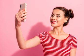 selfie-photography-woman-taking-a-selfie-on-pink-background