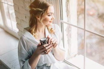 sheer-fashion-trend-woman-in-sheer-looking-out-the-window-drinking-coffee