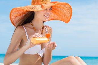 woman-applying-hand-cream-lotion-on-the-beach