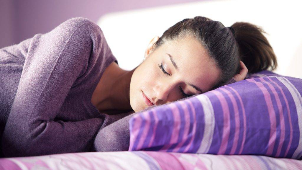 is-sleep-really-the-magical-cure-happy-woman-sleeping-in-purple-pajamas-main-image