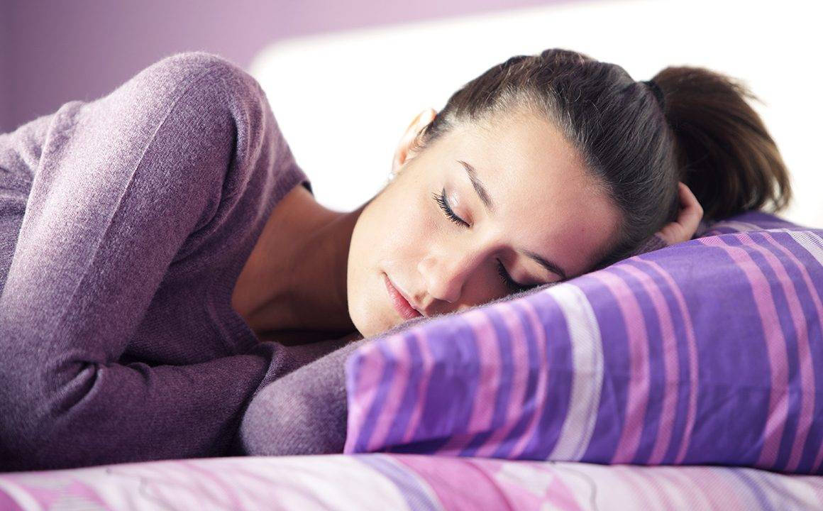 is-sleep-really-the-magical-cure-happy-woman-sleeping-in-purple-pajamas-main-image