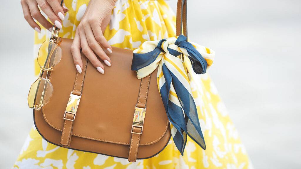 skincare-essentials-every-handbag-needs-woman-in-yellow-with-handbag-main-image