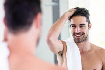 self-care-tips-for-men-man-grooming-his-beard-smiling
