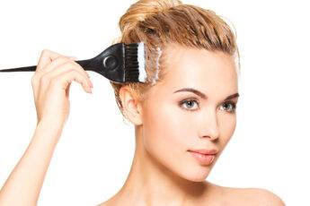fashions-secret-facelift-woman-in-tight-bun-applying-product-on-face