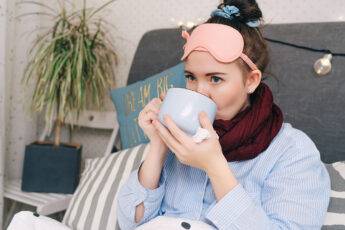 top-5-at-home-self-care-treatments-woman-bundled-up-at-home-drinking-tea