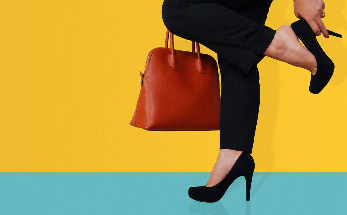 why-do-you-need-comfortable-work-shoes-woman-holding-heel-yellow-background