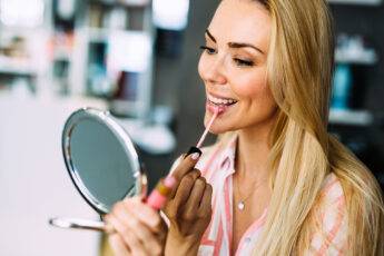 must-try-fashion-and-beauty-trends-woman-applying-lip-gloss-main-image
