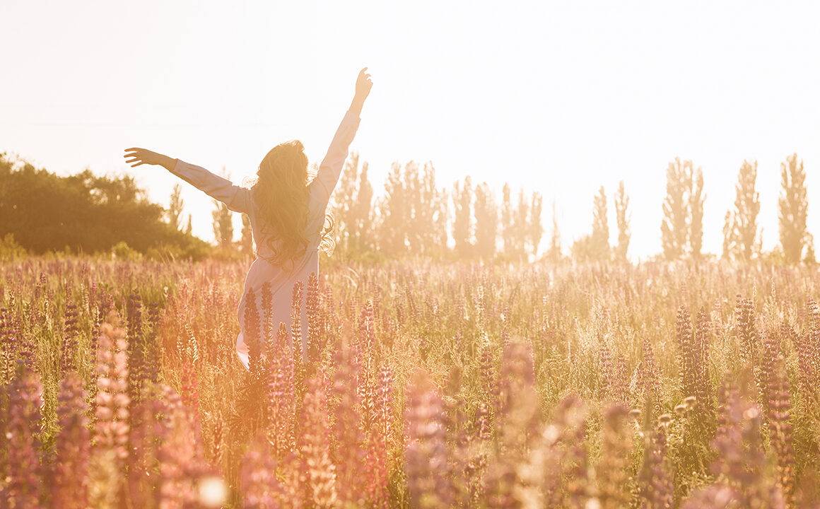 how-to-boost-your-confidence-happy-woman-frolicking-in-field