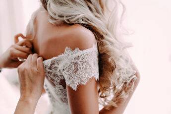 things-to-consider-when-having-your-wedding-dress-tailored-someone-zipping-up-the-wedding-dress