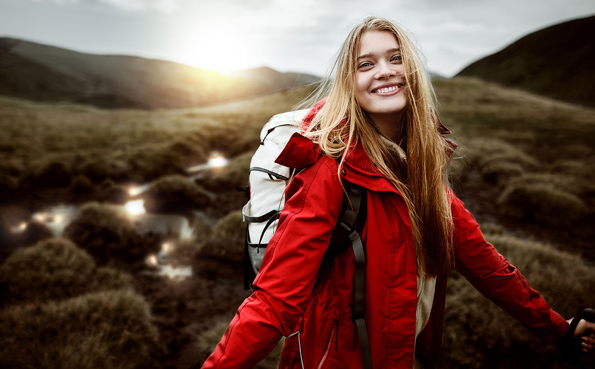 happy-young-woman-hiking-red-jacket