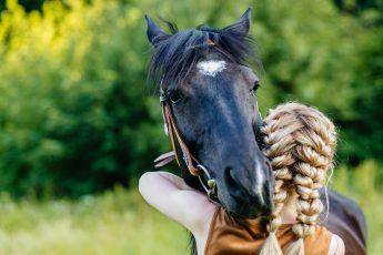 best-hairstyle-for-riding-horses-braided-woman-hugs-horse