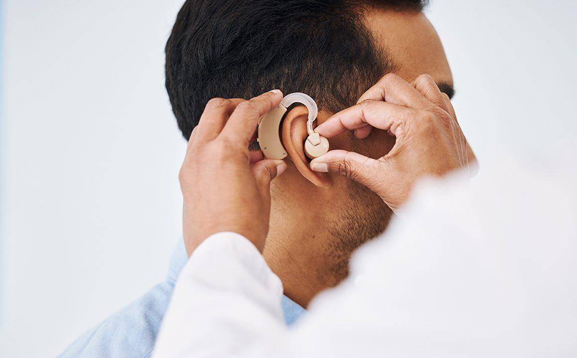 guide-to-audiology-services-man-with-hearing-aid-hearing-doctor