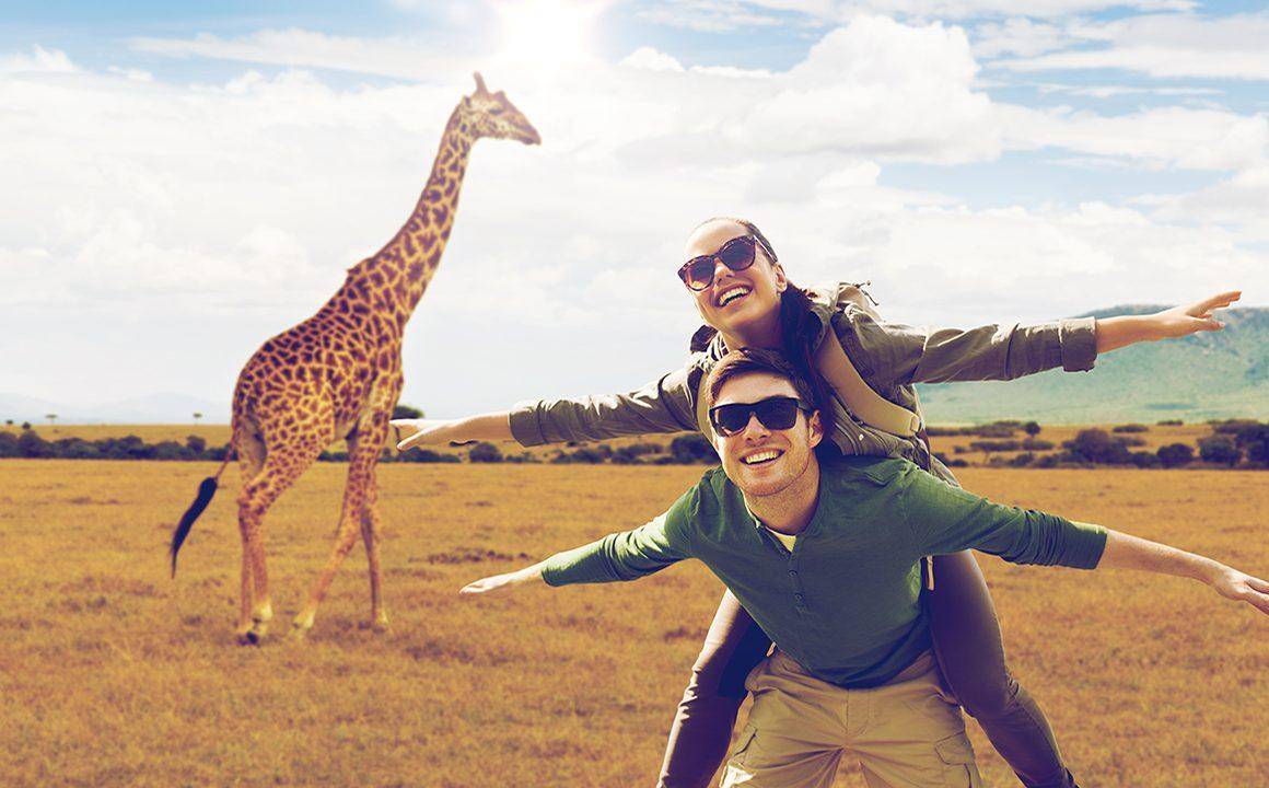 african-safari-couple-being-cute-near-a-giraffe