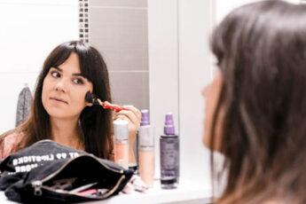 woman applying makeup with brush